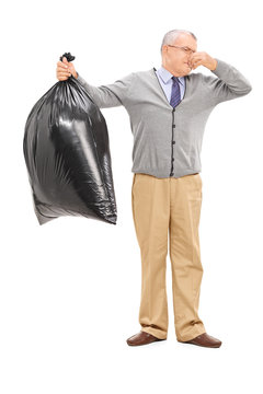 Senior holding a stinky garbage bag