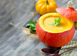 Pumpkin soup with fresh pumpkins copy space background