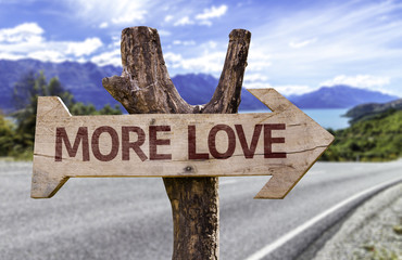 More Love wooden sign with a landscape background