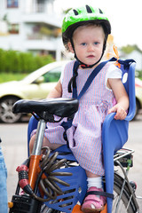 Obraz premium Child sits strapped in the seat bicycle