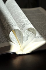 Closeup pages of an open book, with heart shaped pages