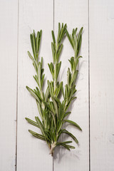 Rosemary on a wooden table, top view