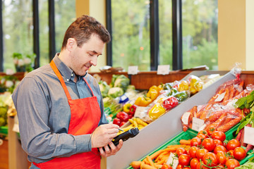 Marktleiter in Supermarkt mit Datenerfassungsgerät