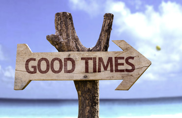 Good Times wooden sign with a beach on background