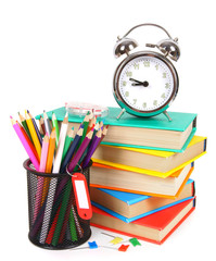 Books, an alarm clock and school tools.