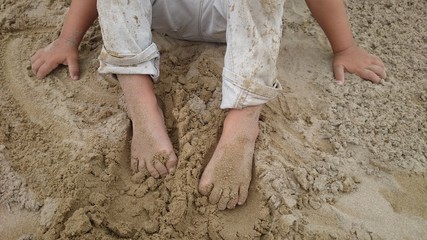 Obraz na płótnie Canvas Kinderhände und Füße im Sand