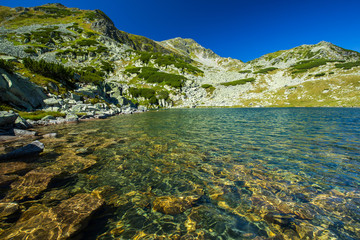 Fototapeta na wymiar Clear mountain lake in the Alps in the summer