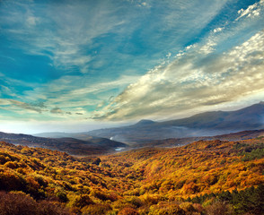 Fototapeta na wymiar Mountain landscape, autumn forest on a hillside, under the sky