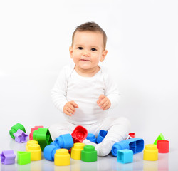 Fototapeta na wymiar Beautiful baby girl with colorful toys - Studio shot