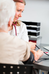 Doktor behandelt Seniorin in Arztpraxis
