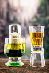 Yellow green cocktail inside a glass and shot