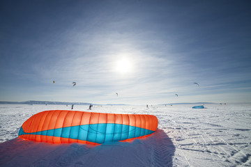 Kiteboarder with blue kite on the snow