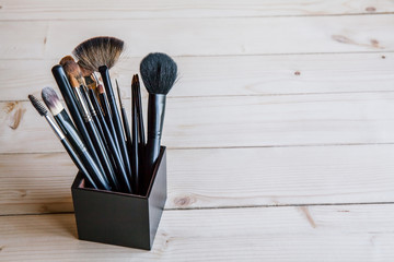 make-up brushes in a black glass