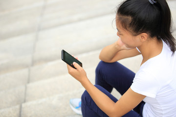 young asian woman use smart phone sit on stairs 