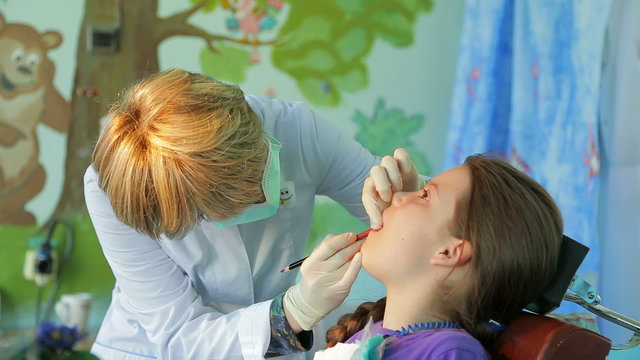 Dentist Fitting And Measuring Braces In Girl’s Mouth