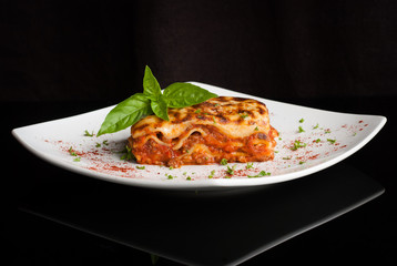 Lasagna on a square white plate