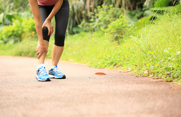 woman runner hold her sports injured knee 