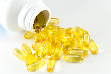 Vitamin Omega-3 fish oil capsules near a bottle