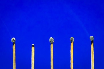 burned match setting on blue background for ideas and inspiratio