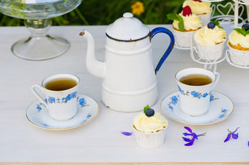 Tea with cupcakes in a vintage teapot