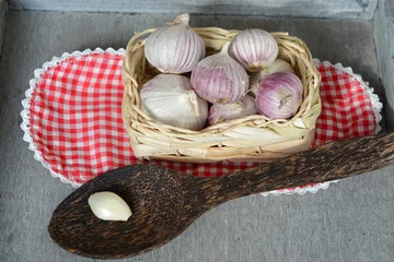 Tapeten Knoflook in een mandje met kleedje en pollepel © trinetuzun