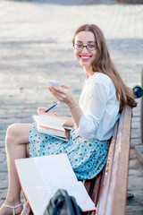 Young woman sitting and studying on the bench