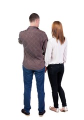 Back view of young embracing couple (man and woman) hug and look