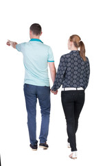 Fototapeta premium Back view of walking young couple (man and woman) pointing.