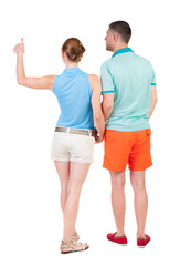 young couple pointing at wal Back view