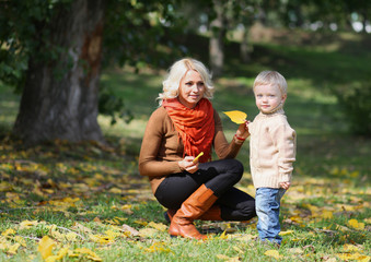 Fototapeta premium Mother and child having fun in autumn park