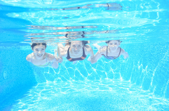 Happy family swim underwater in pool and having fun