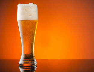 Glass of beer with orange background
