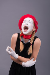 Fototapeta na wymiar Portrait of female mime in red head and with white face isolated