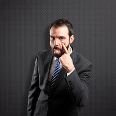 Young businessman making a mockery over black background