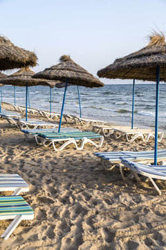 Sun umbrella on an empty beach and sea water horizon.