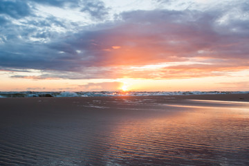 Fototapeta na wymiar Sea beach at sunset with water splashes