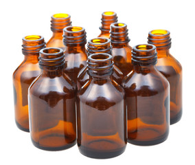many small open amber glass oval pharmacy bottles
