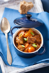 beef stew with potato and carrot in blue pot