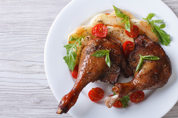 duck legs roasted with apples and tomatoes close-up top view