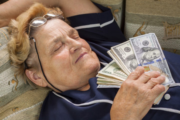 Woman pensioner sleeping with money in her hand