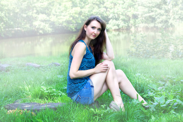 Naklejka na ściany i meble Woman sitting in foggy park by the lake