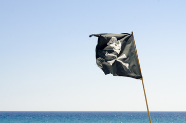 pirate flag waving with blue sea background