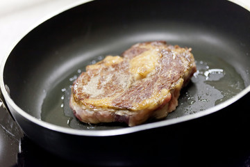 beef steak in a frying pan
