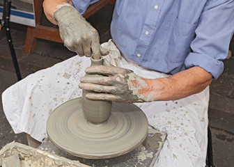 potter shaping clay on a potter's wheel