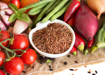 Red organic rice in bowl and vegetables