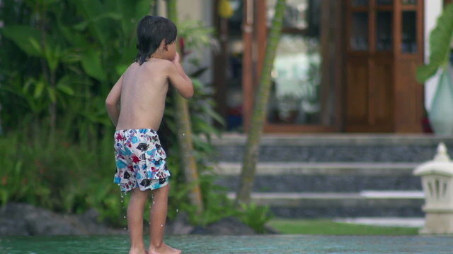 Boy jumping to the pool and diving, slow motion shot