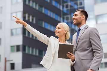 smiling businessmen with tablet pc outdoors