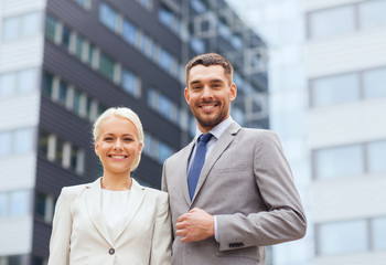 smiling businessmen standing over office building