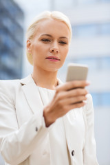 serious businesswoman with smartphone outdoors