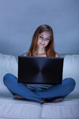 Girl using laptop on sofa